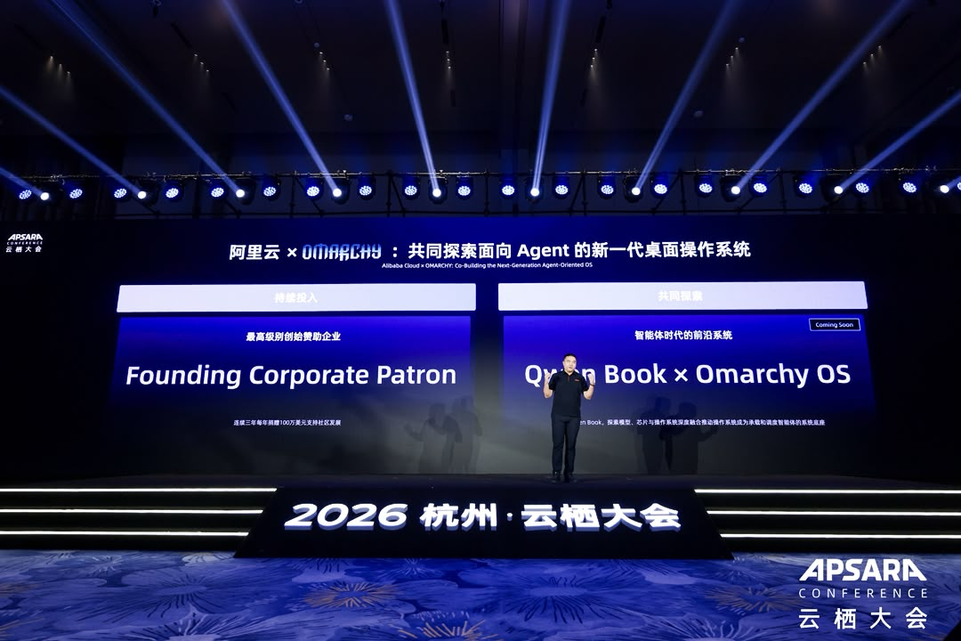 Hangzhou-வில் 2026 Apsara Conference மேடையில் Omarchy உடனான Founding Corporate Patron உறுதிமொழி மற்றும் Qwen Book ஒத்துழைப்பை Alibaba Cloud அறிவிக்கிறது.
